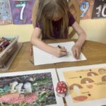 To keep her attention, lessons are short with plenty of room for self-expression. Here she is drawing a mushroom.